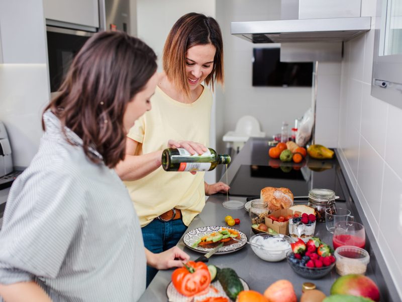 Women preparing healthy food in kitchen having fun, concept dieting nutrition.